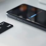 Smartphone mit vollem Mobilfunksignal neben einer deutschen SIM-Karte – 1und1 welches Netz